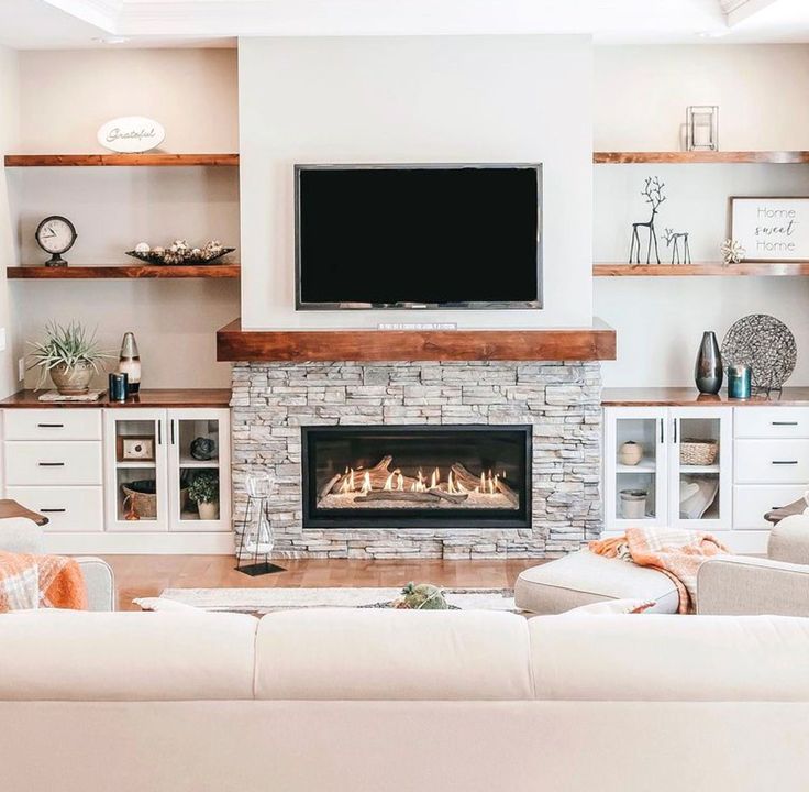 a living room filled with furniture and a flat screen tv mounted above a fire place