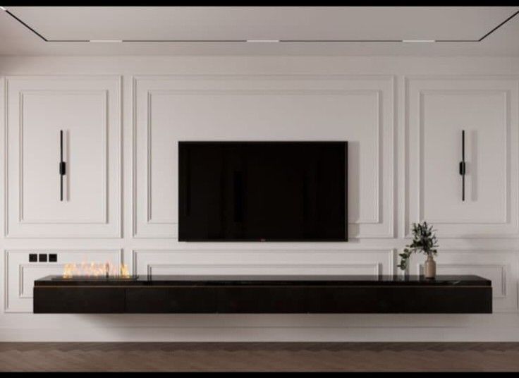 a living room with white cabinets and a flat screen tv mounted on the wall above it