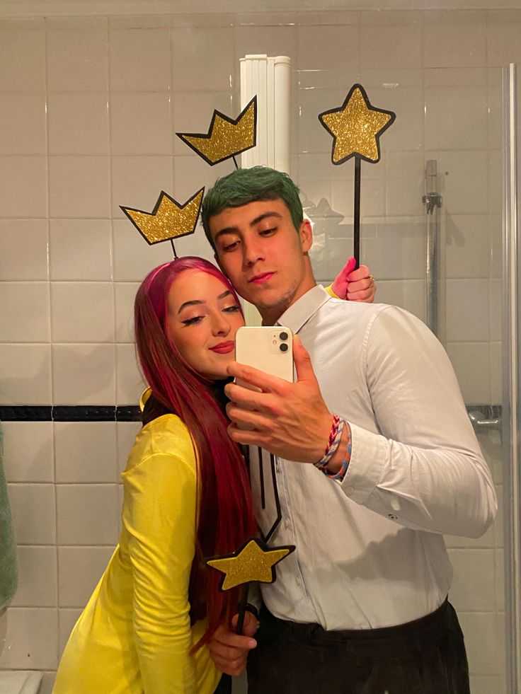 a man and woman taking a selfie in a bathroom with stars on the wall