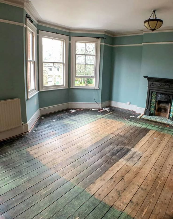 an empty room with wood floors and blue walls