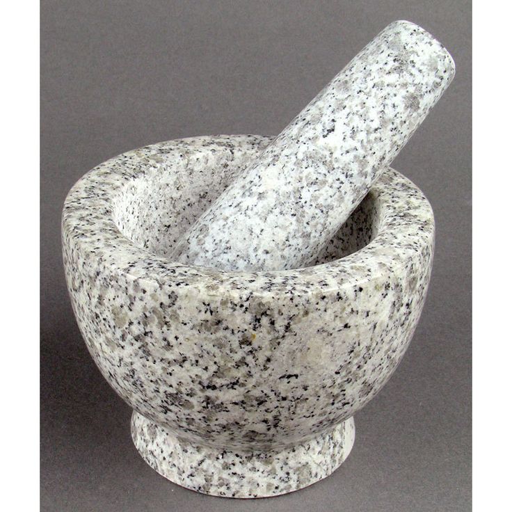 a mortar and pestle set on a gray surface with a black doted background