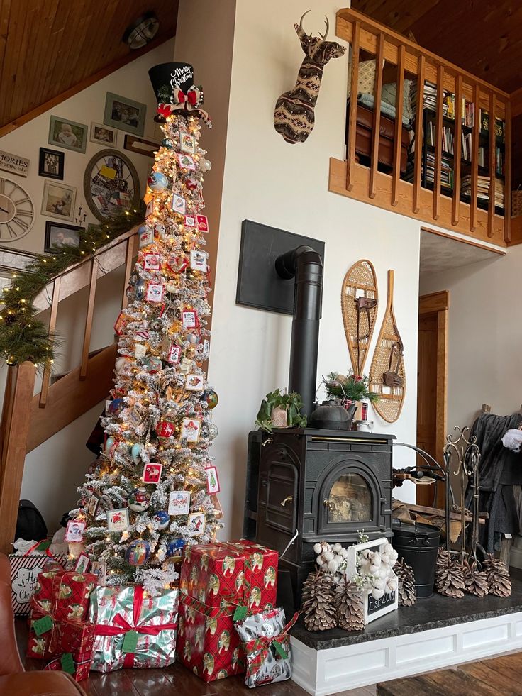 a living room filled with lots of presents under a wooden bannister next to a christmas tree