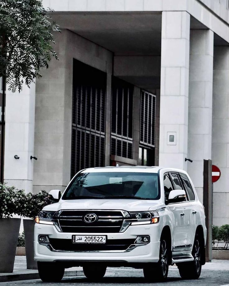 a white suv parked in front of a building