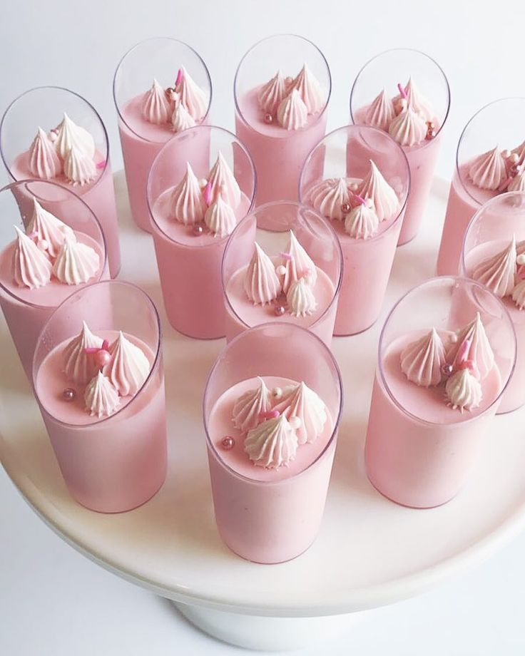 there are many pink desserts in small cups