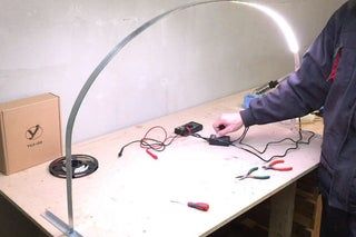 a man standing next to a table with wires on it