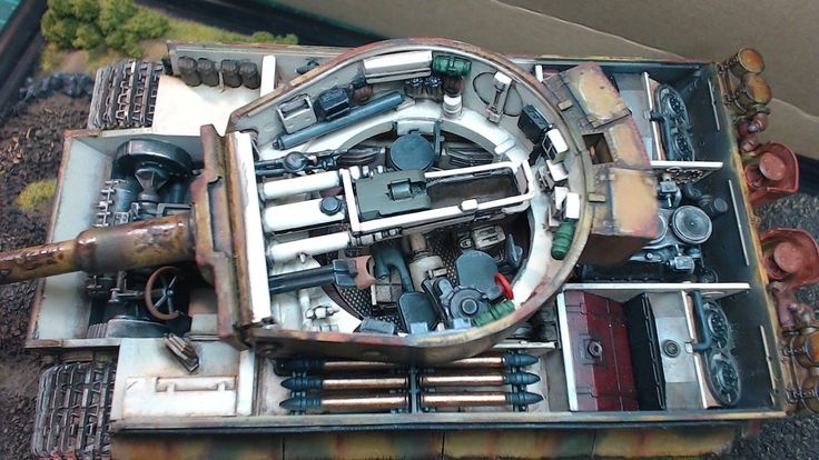 the inside of an old model tank with metal parts on it's sides and wheels