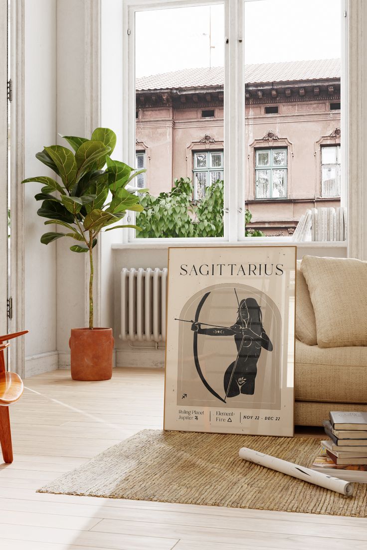 a book sitting on top of a wooden floor next to a plant in a living room