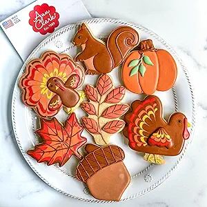 decorated cookies are sitting on a plate next to an envelope with the word happy thanksgiving