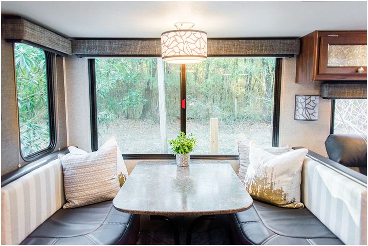 a dinning room with a table and two couches in front of a window