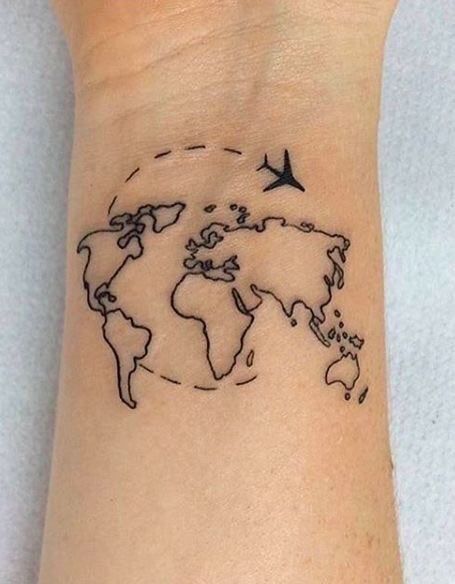 a small wrist tattoo with a world map and birds on the back of its arm