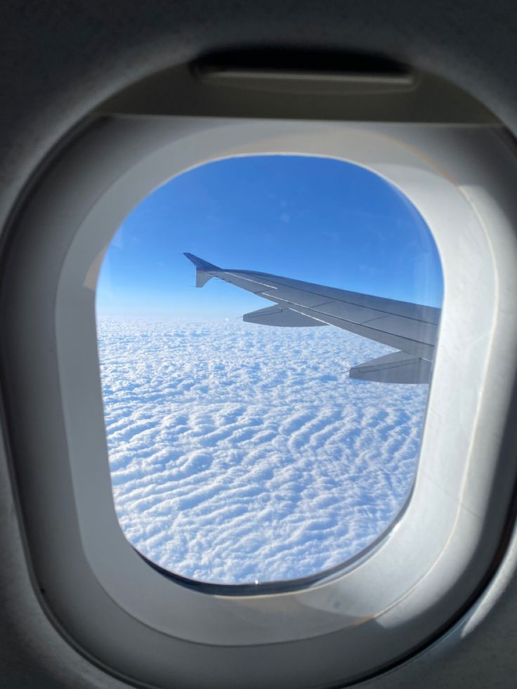 an airplane window looking out into the clouds