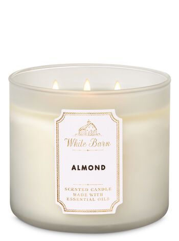 a white candle with an orange label on the top and bottom, in front of a white background