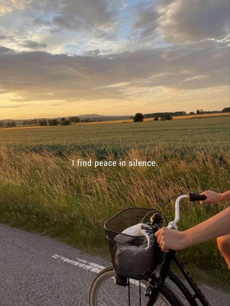 a person riding a bike down a road with the words i find peace in silence