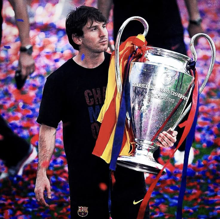 a man holding a soccer trophy in front of confetti