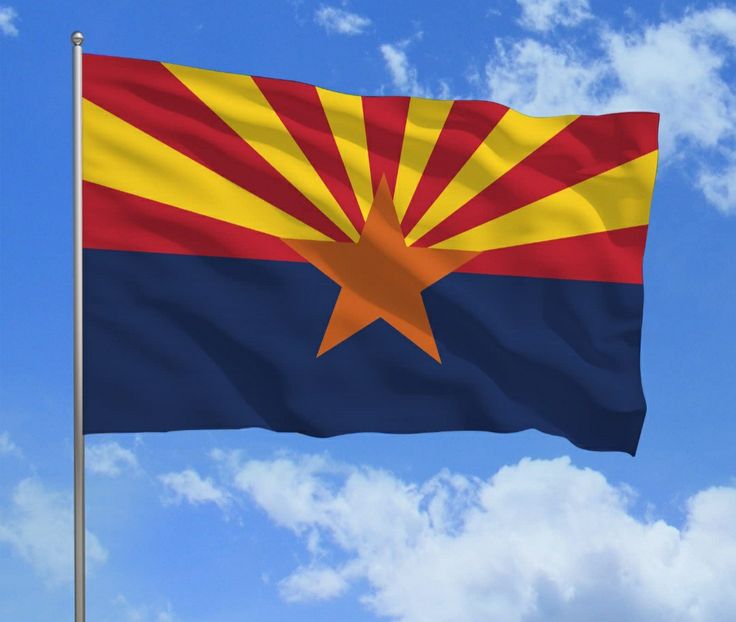 the arizona state flag is flying high in the blue sky with white clouds behind it