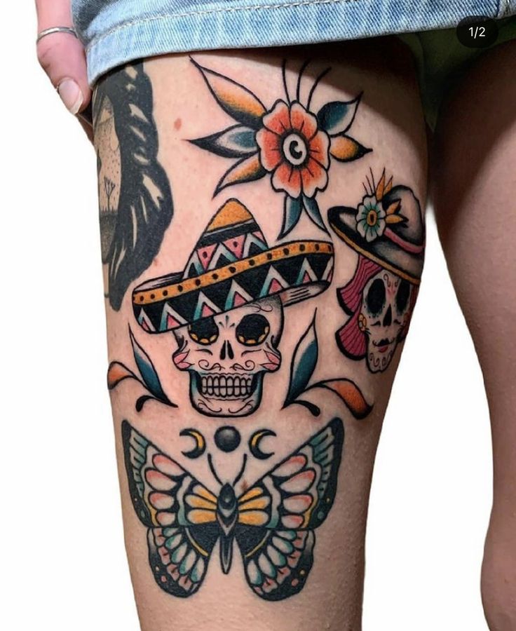 a woman's thigh with tattoos on it and a skull wearing a sombrero