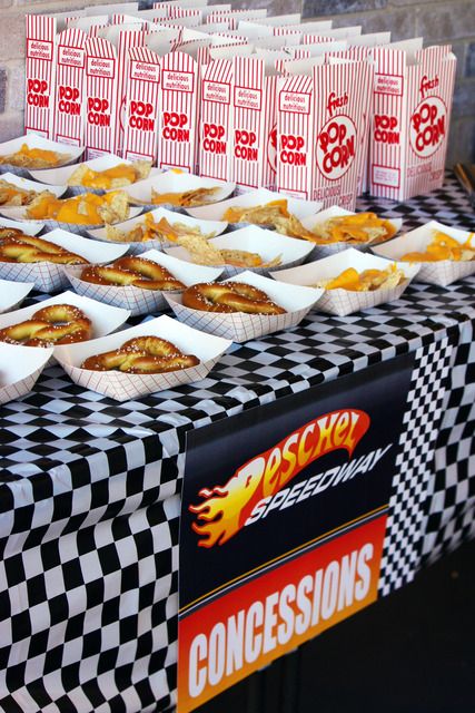 some food is sitting on a table with checkered cloth and paper bags next to it