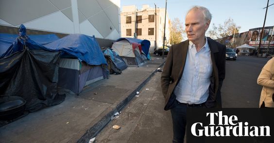 an older man standing on the sidewalk next to tents