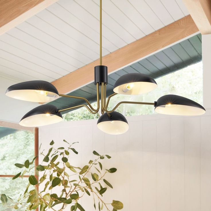 a light fixture hanging from the ceiling in a room with white walls and wood beams