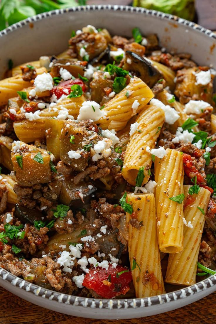 a bowl filled with pasta and meat covered in fettuccine, parmesan cheese