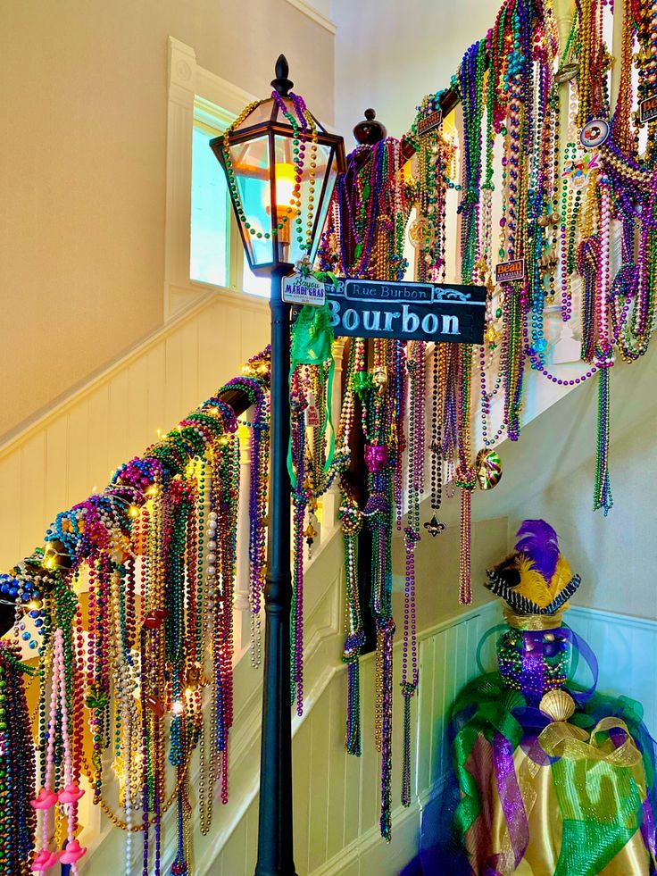 there is a street sign that says bourbon on it and lots of beads hanging from the wall