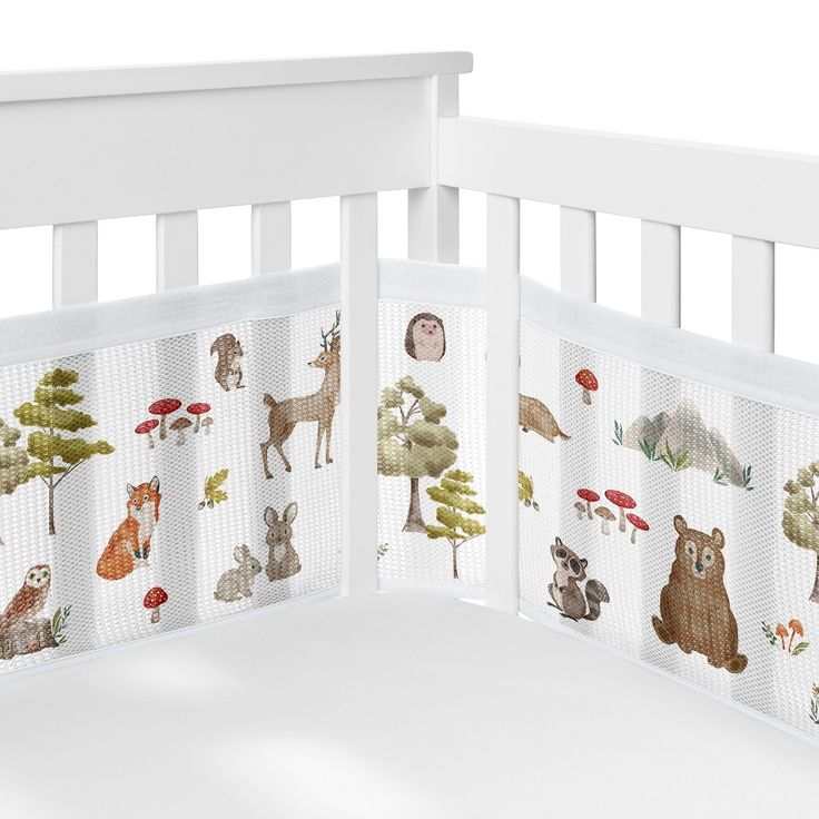 a white crib with animals and trees on it