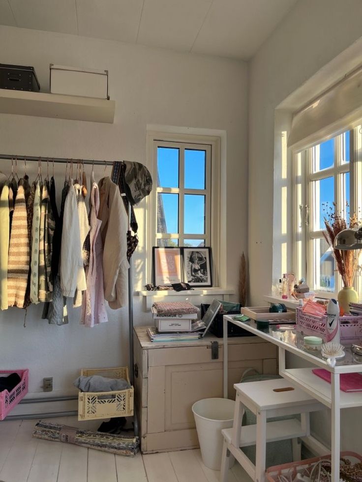 a room that has some clothes hanging on the wall and other things in the window