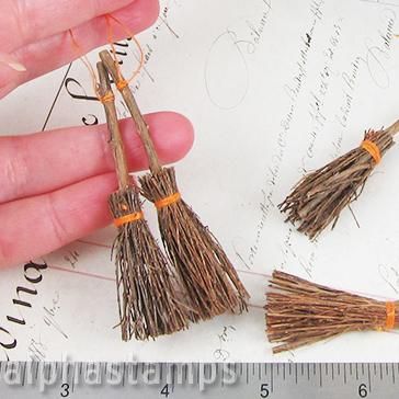 someone is holding two small brooms on top of a piece of paper with writing