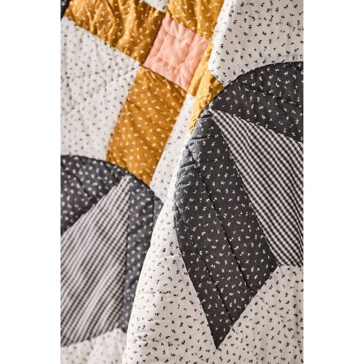 a close up of a quilt on a bed with black and white polka doting