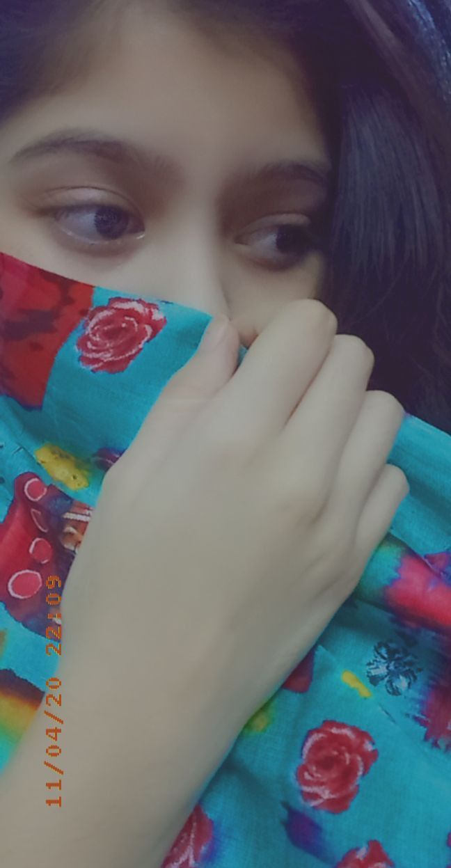 a woman covering her face with a colorful scarf