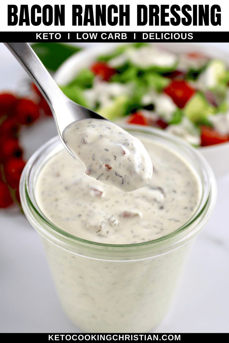 a spoon full of ranch dressing next to a salad