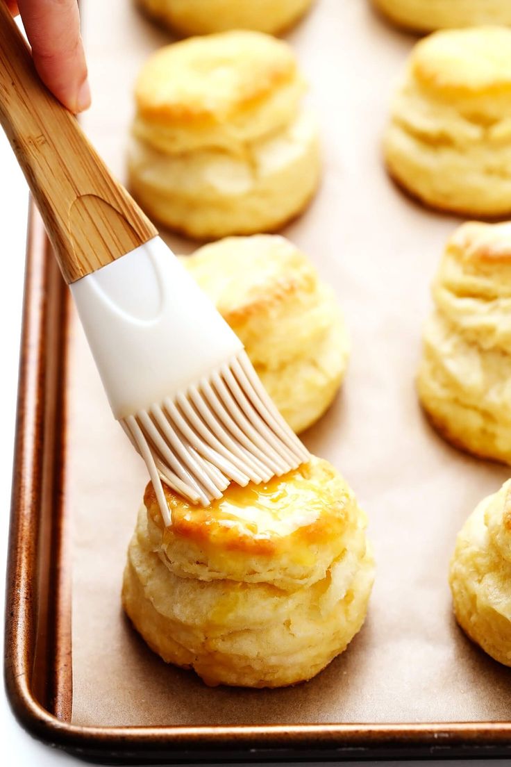 a hand with a brush on top of some biscuits