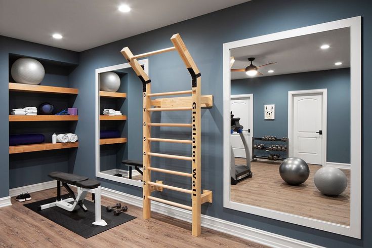 a gym with exercise equipment and mirrors in the wall, as well as an exercise bench