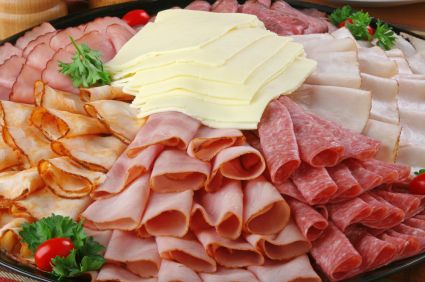 an assortment of meats and cheeses on a platter