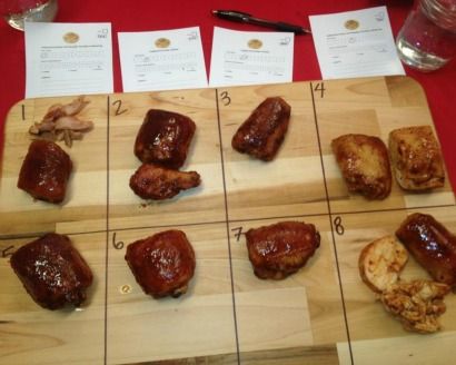 a wooden cutting board topped with lots of meats on top of a red table