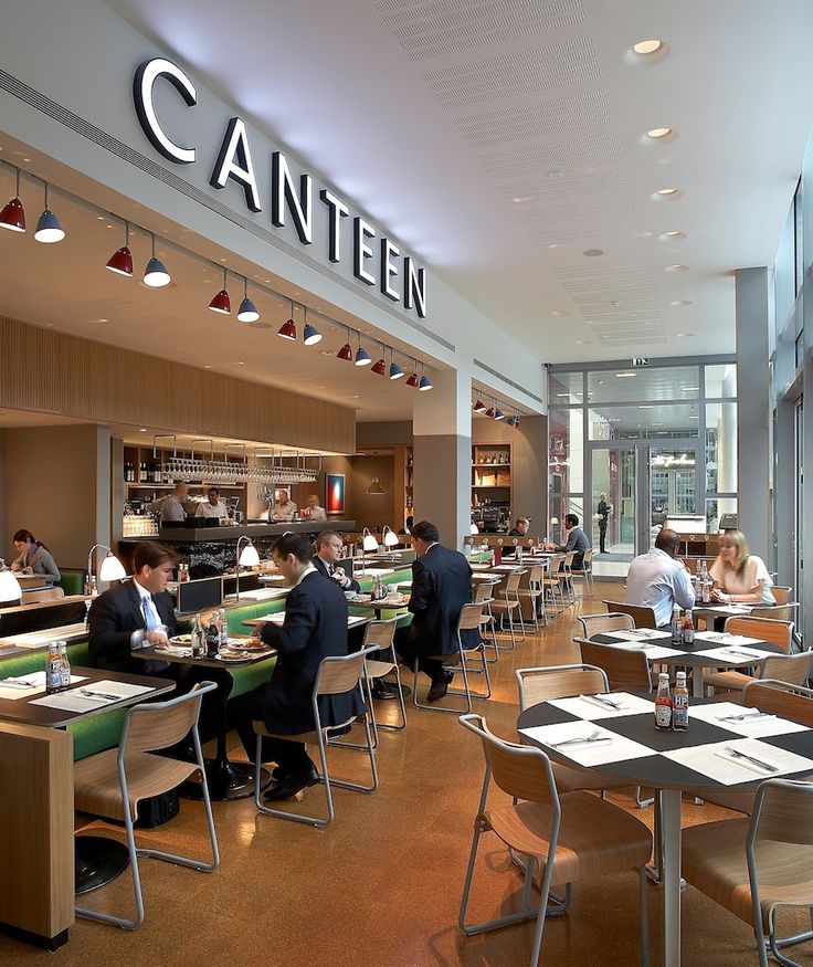 people sitting at tables in a restaurant with the name canten on the wall above them