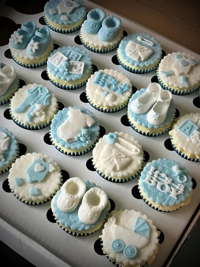 a box filled with lots of cupcakes covered in blue and white icing