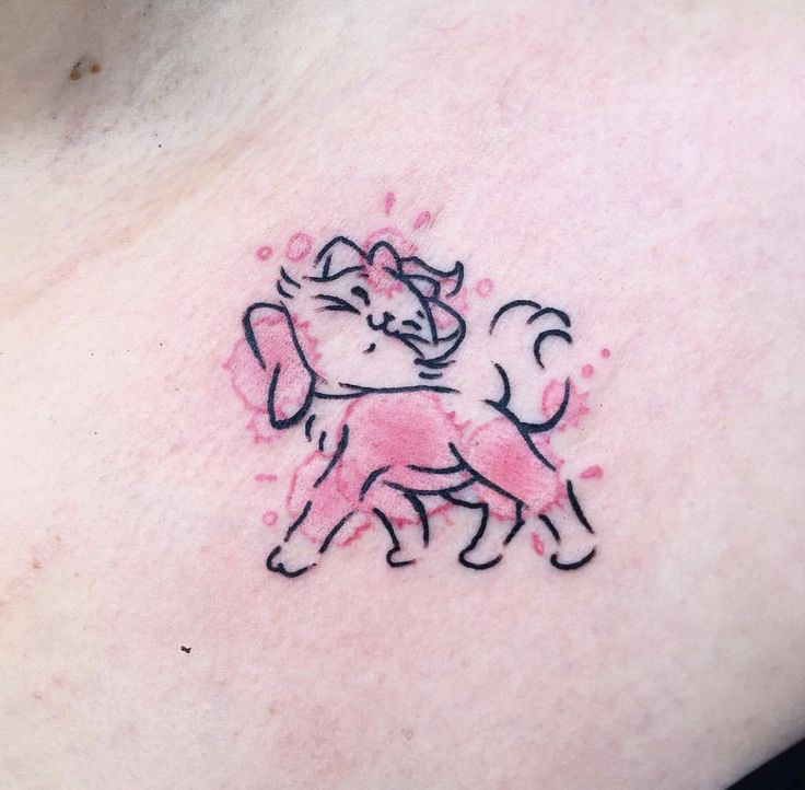 a woman's chest with a small tattoo of a cat on the left side