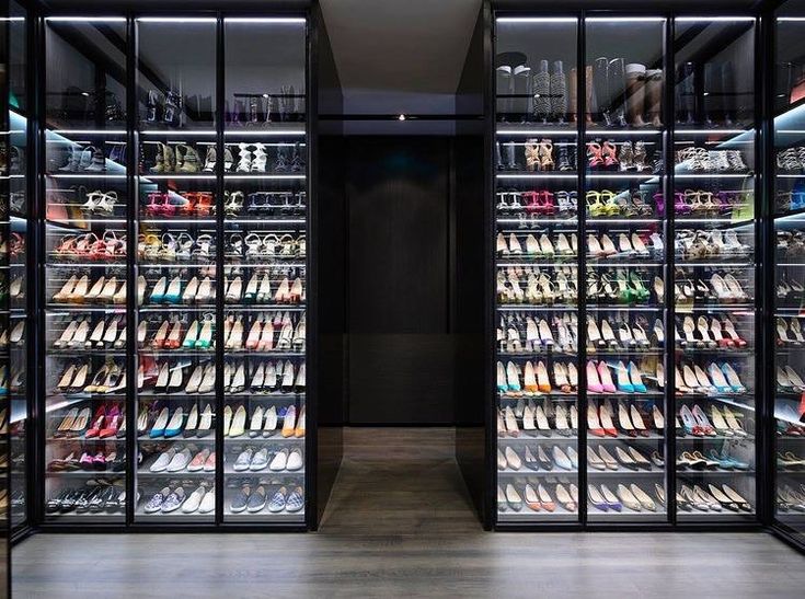 the inside of a shoe store with many rows of shoes in glass cases on both sides