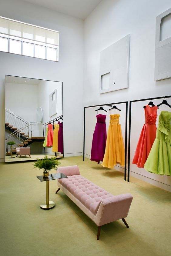 there are dresses on display in the store and one is pink, green, yellow and orange