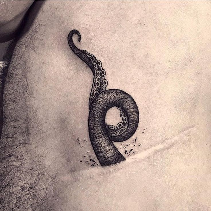 a man's stomach with an octopus tattoo on his chest and the letter o