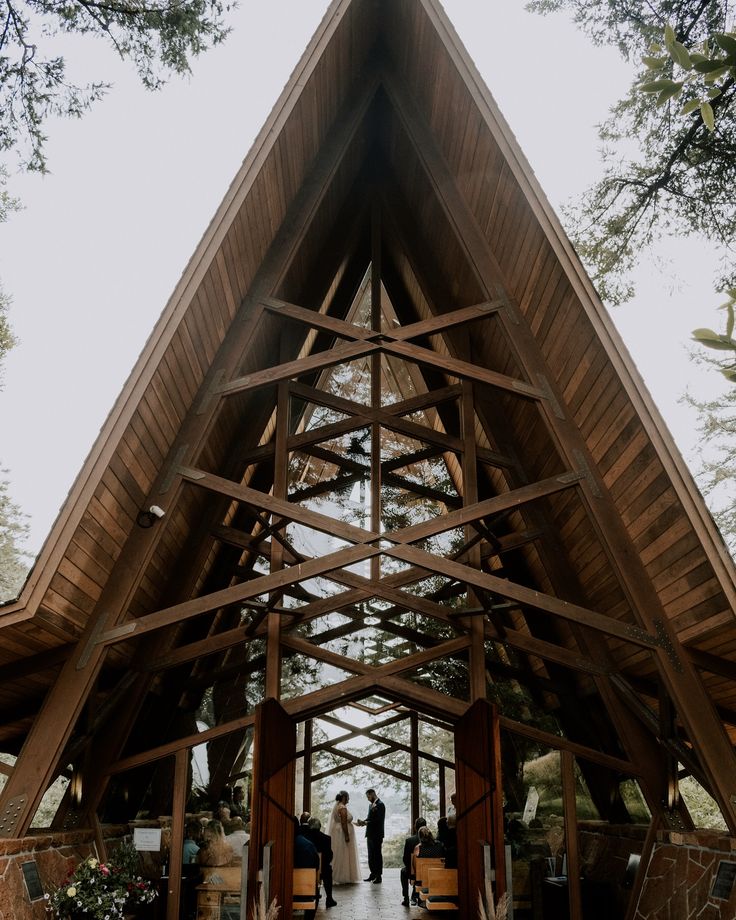 a couple getting married in front of a large wooden structure at the end of their wedding ceremony