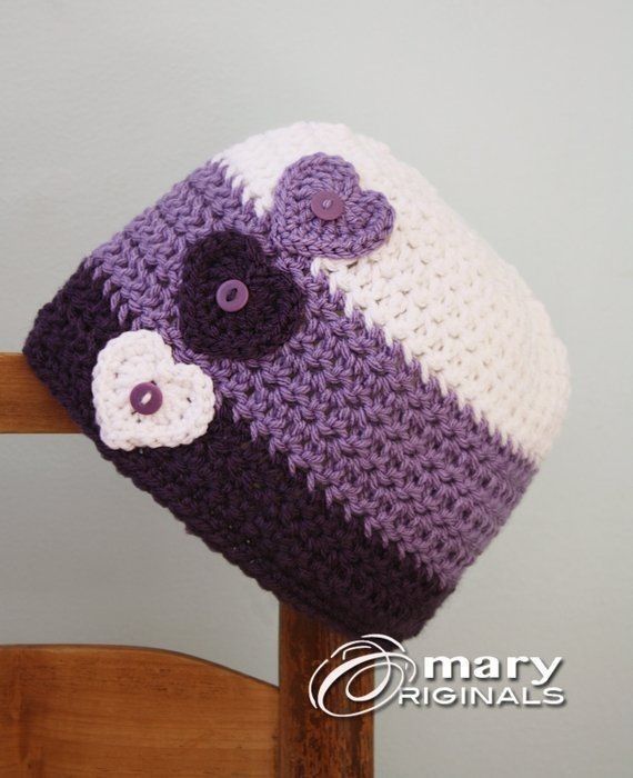 a purple and white crocheted hat sitting on top of a wooden chair