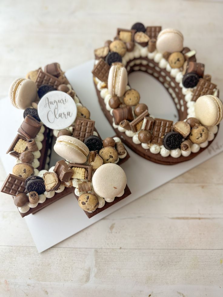 a cake shaped like the letter o is decorated with chocolate, cookies and marshmallows