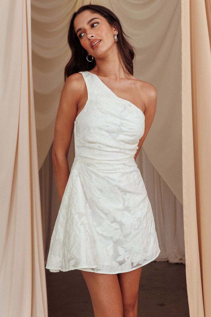 a woman in a white dress posing for the camera