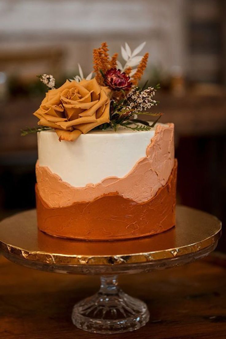 a close up of a cake on a plate with frosting and flowers in the middle