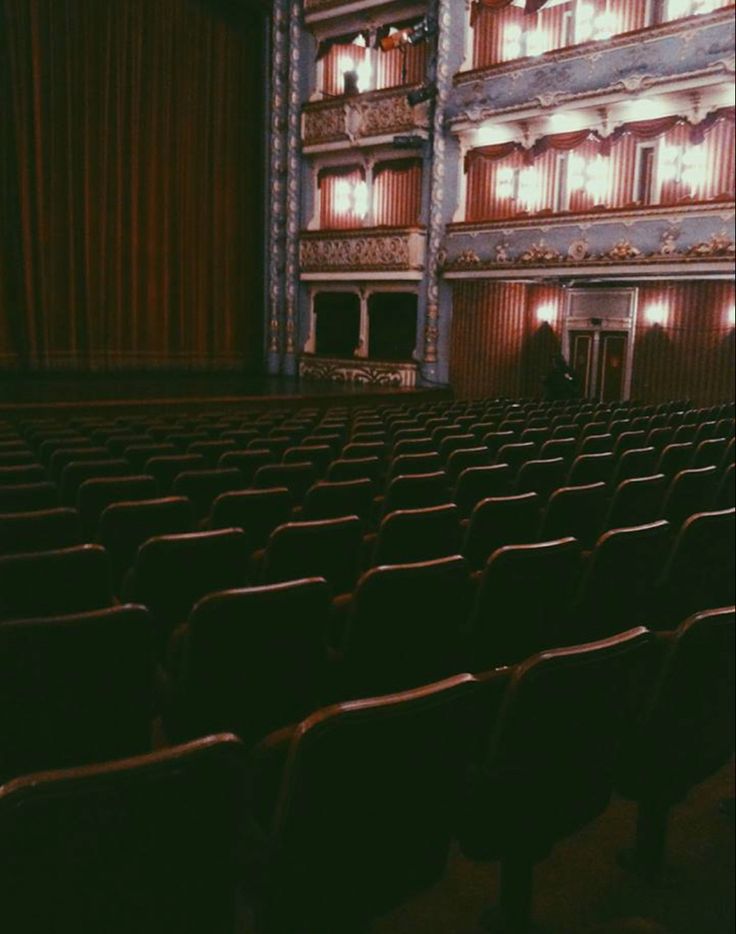 an empty theater with rows of seats facing the stage