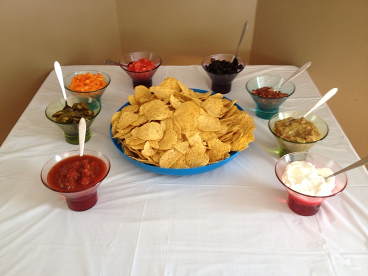 a table topped with bowls filled with chips and salsa