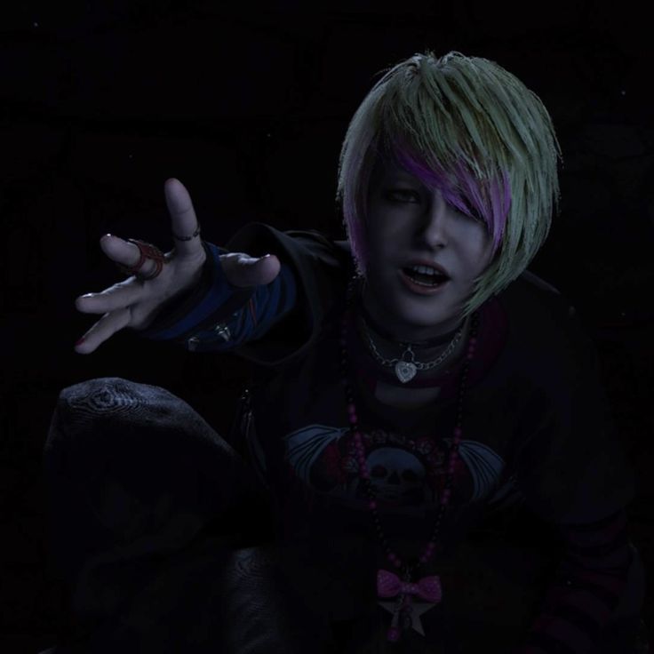 a young man with pink hair and piercings in the dark holding his hands out