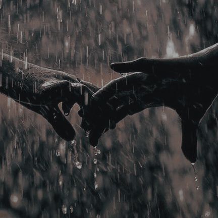 two hands holding each other in the rain